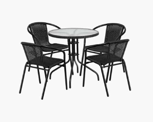 Four-piece outdoor dining set with a round glass table and black wicker chairs, ideal for patio or garden use